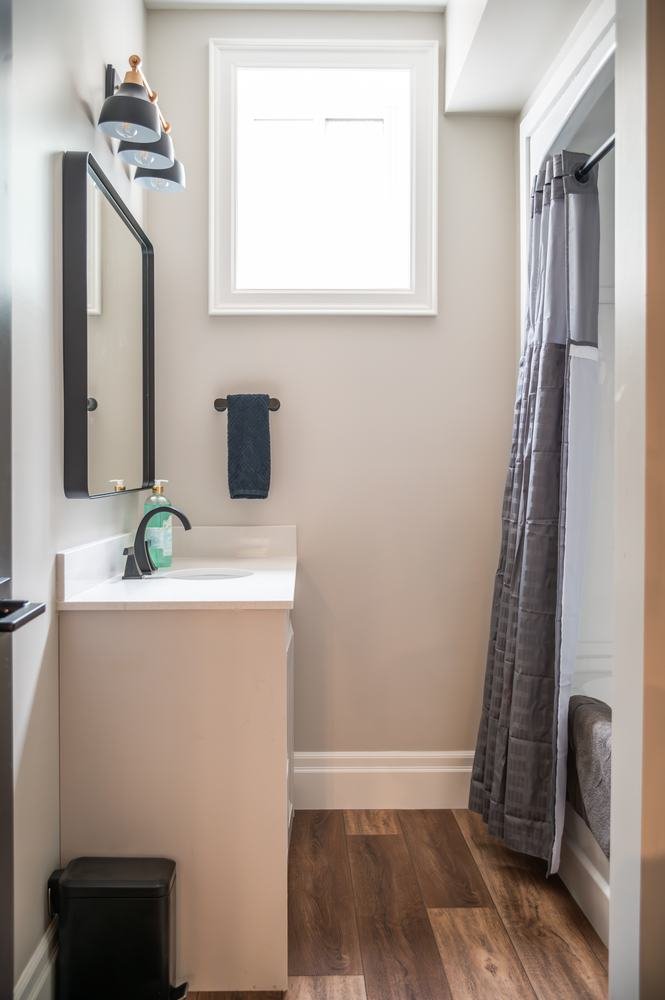 Small bathroom vanity beneath a mirror and window