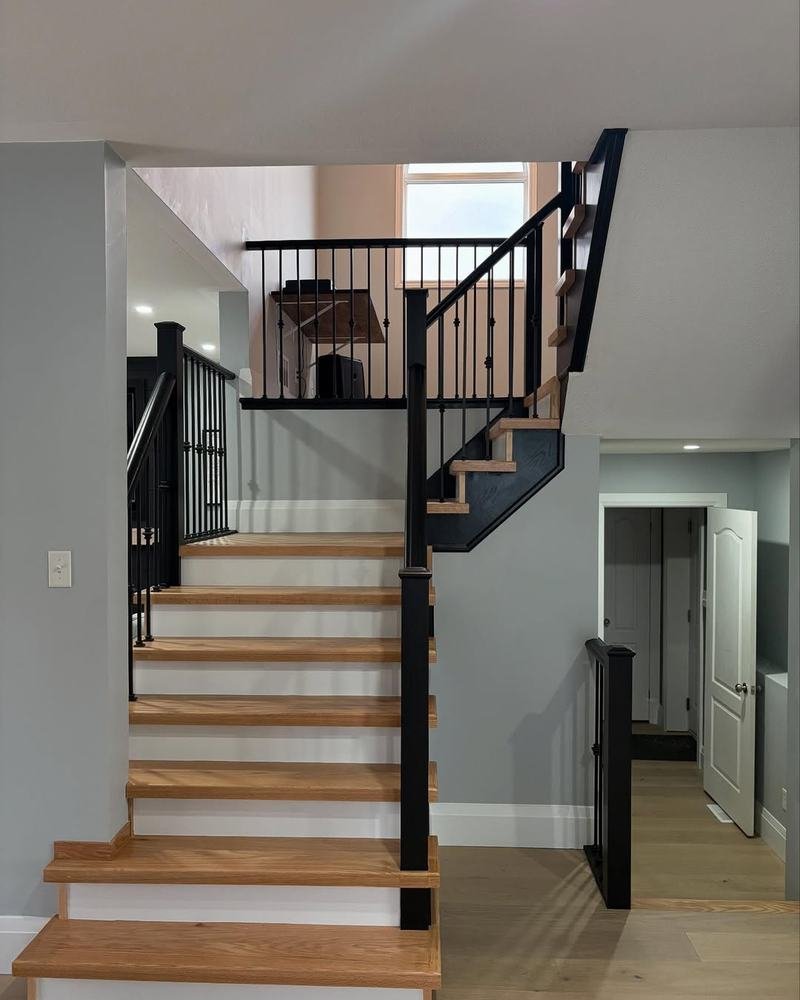 Modern multi-level staircase with pale treads and black railing