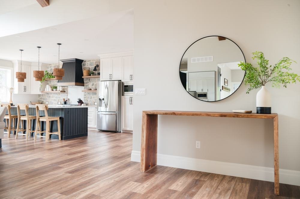 Open-plan kitchen and dining space with a dark island and wood flooring