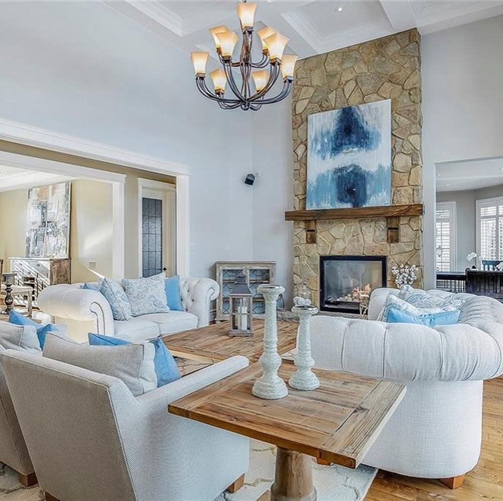 Natural-stone fireplace in a bright living room with pale furnishings