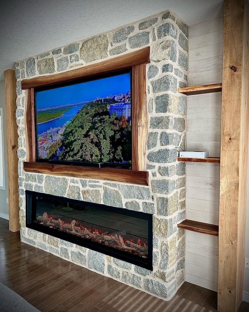 Two-sided stone fireplace and television wall with timber trim