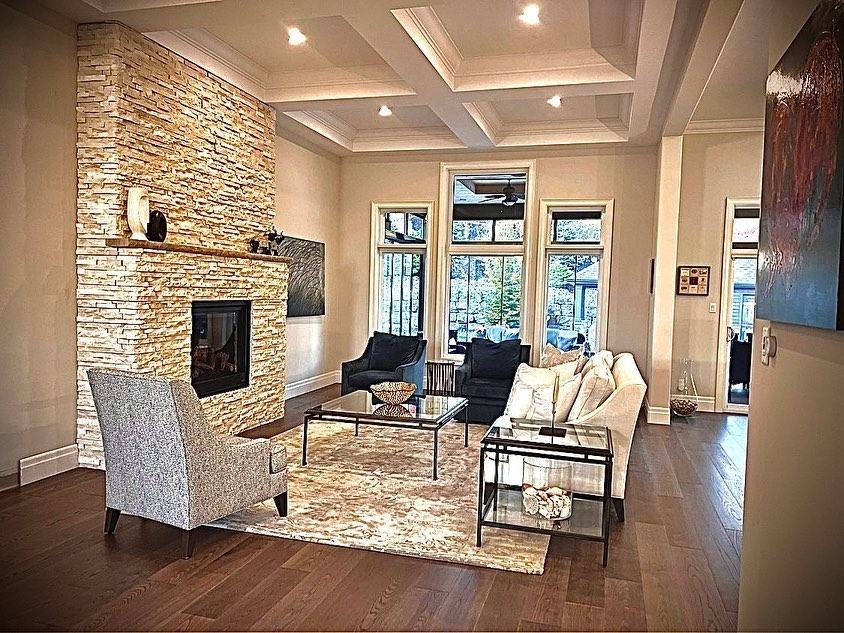 Elegant living room with a tall ledgestone fireplace and coffered ceiling