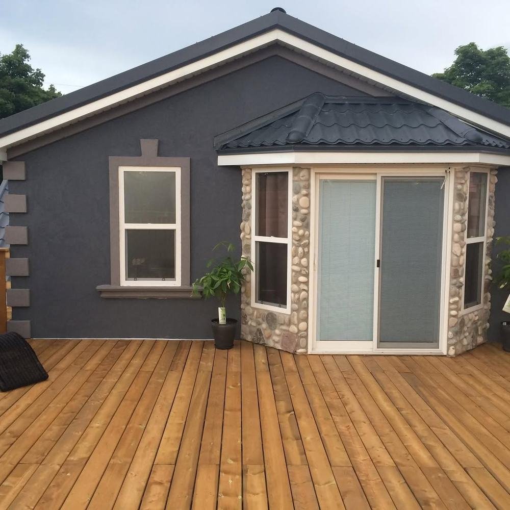 Stone-clad rear addition opening onto a broad new wood deck