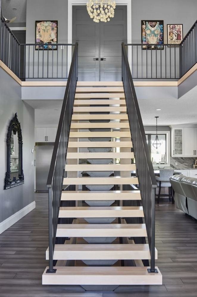 Modern central staircase with pale treads, dark railings, and symmetrical upper landing