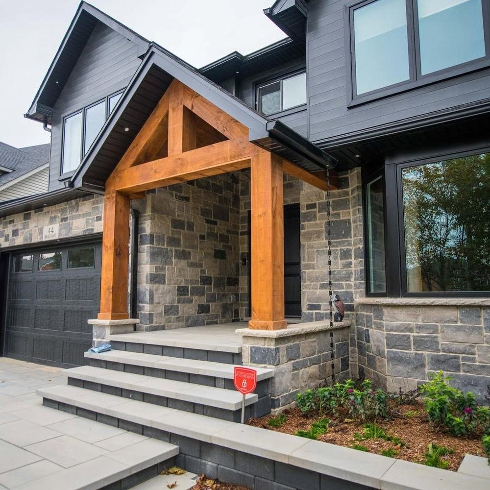 Stone-clad home entrance with timber posts and broad front steps