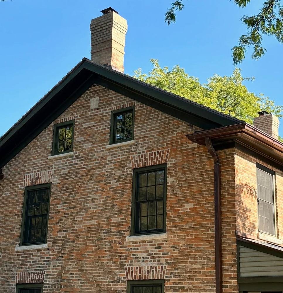Upper brick facade and masonry chimney on an older building