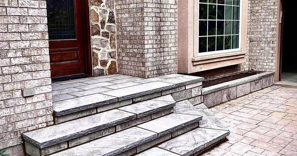 Stone entry steps and landing beside brick and natural-stone walls